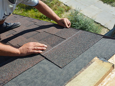 Closeup of someone repairing shingles on a roof