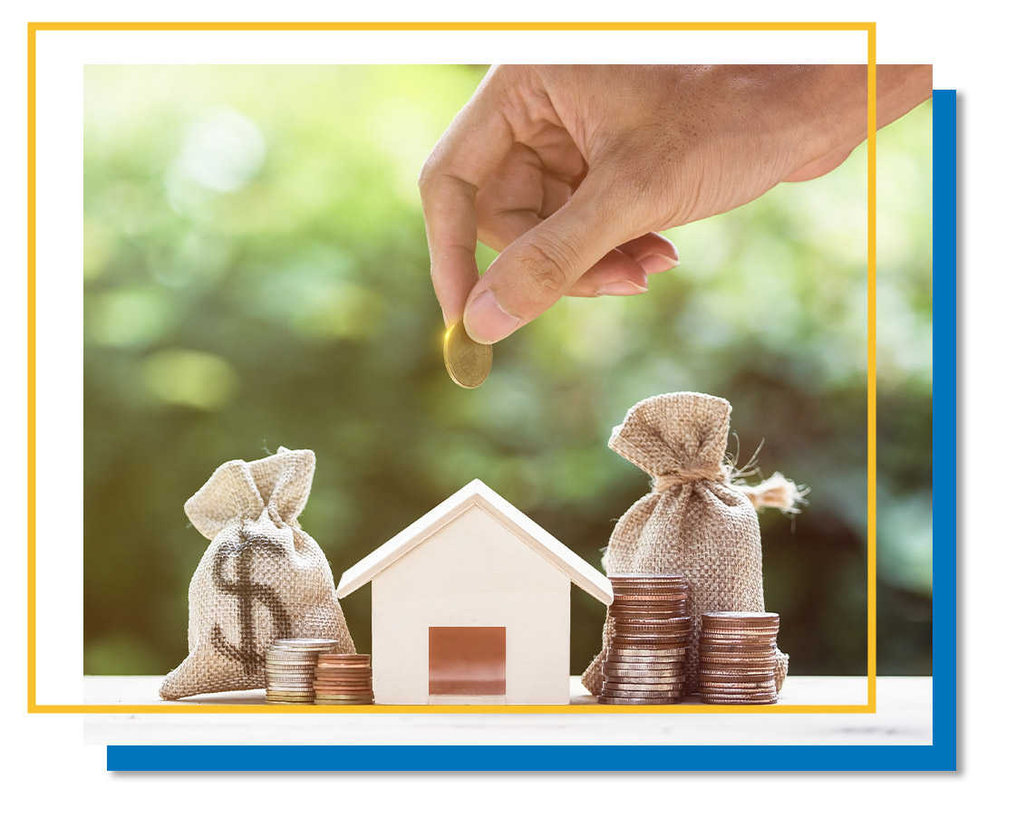 a mini house surrounded by money with a hand adding more money